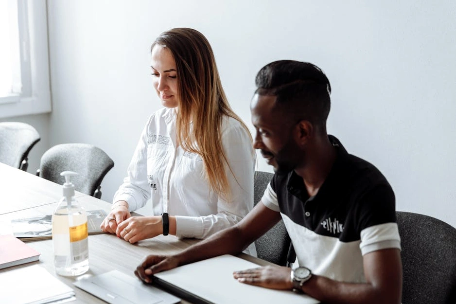 Usměvavý zakladatel startupu při práci na notebooku.